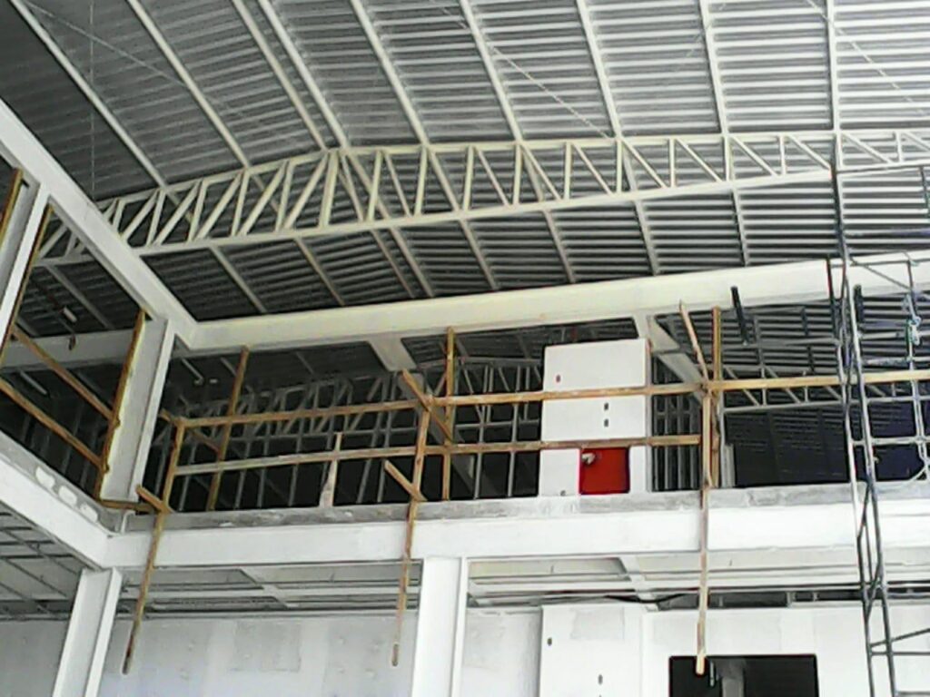Treliça metálica posicionada no telhado de galpão para reforço estrutural industrial