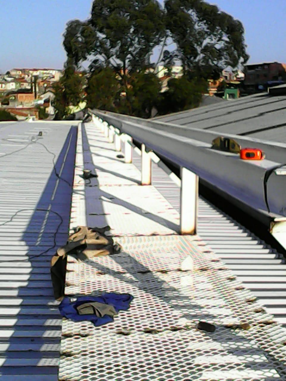 Plataforma branca instalada para circulação segura sobre telhado galvanizado