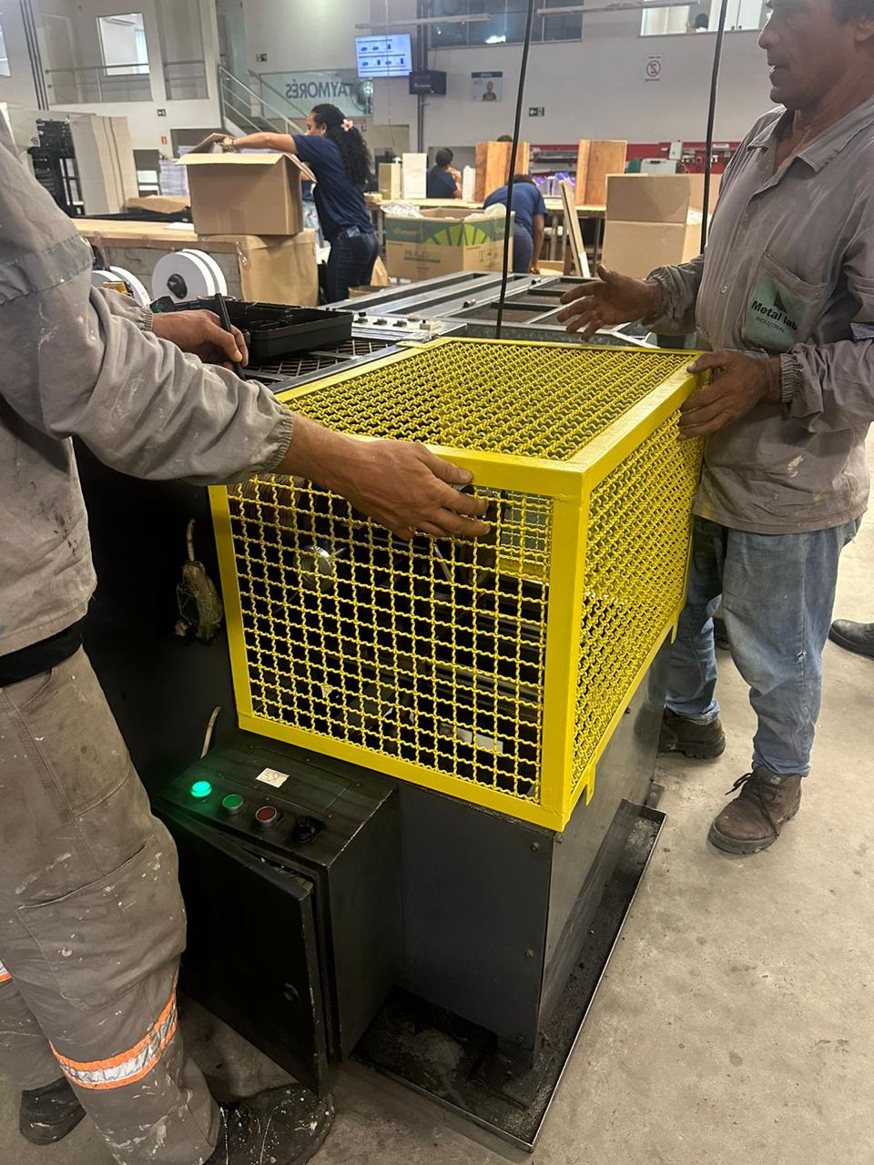 Equipe da LC Engenharia instalando proteção NR-12 em uma enroladeira de alça de sacola na indústria
