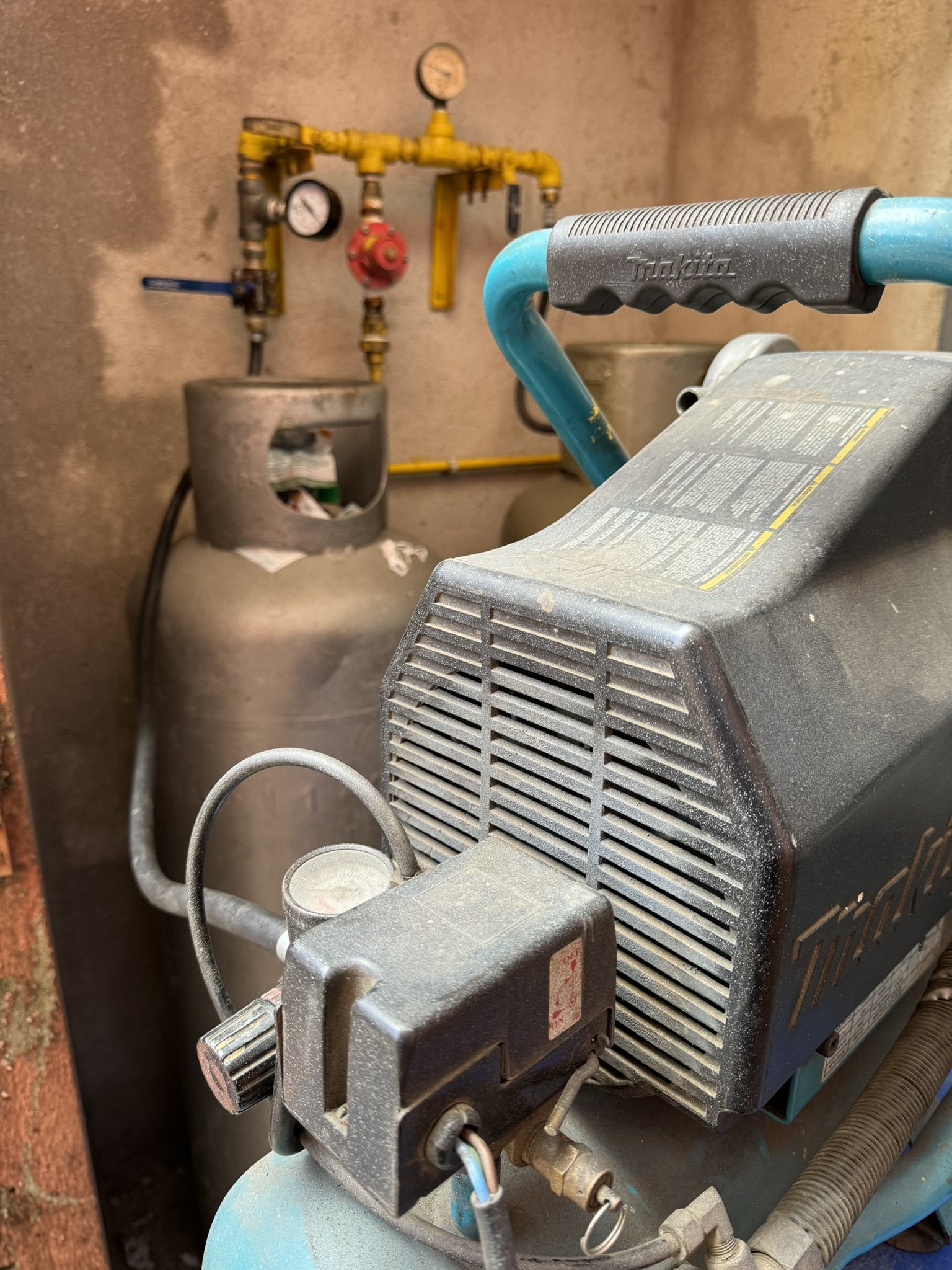 Compressor utilizado pela LC Engenharia em teste de estanqueidade de sistema de gás GLP, com tanques de armazenamento ao fundo.