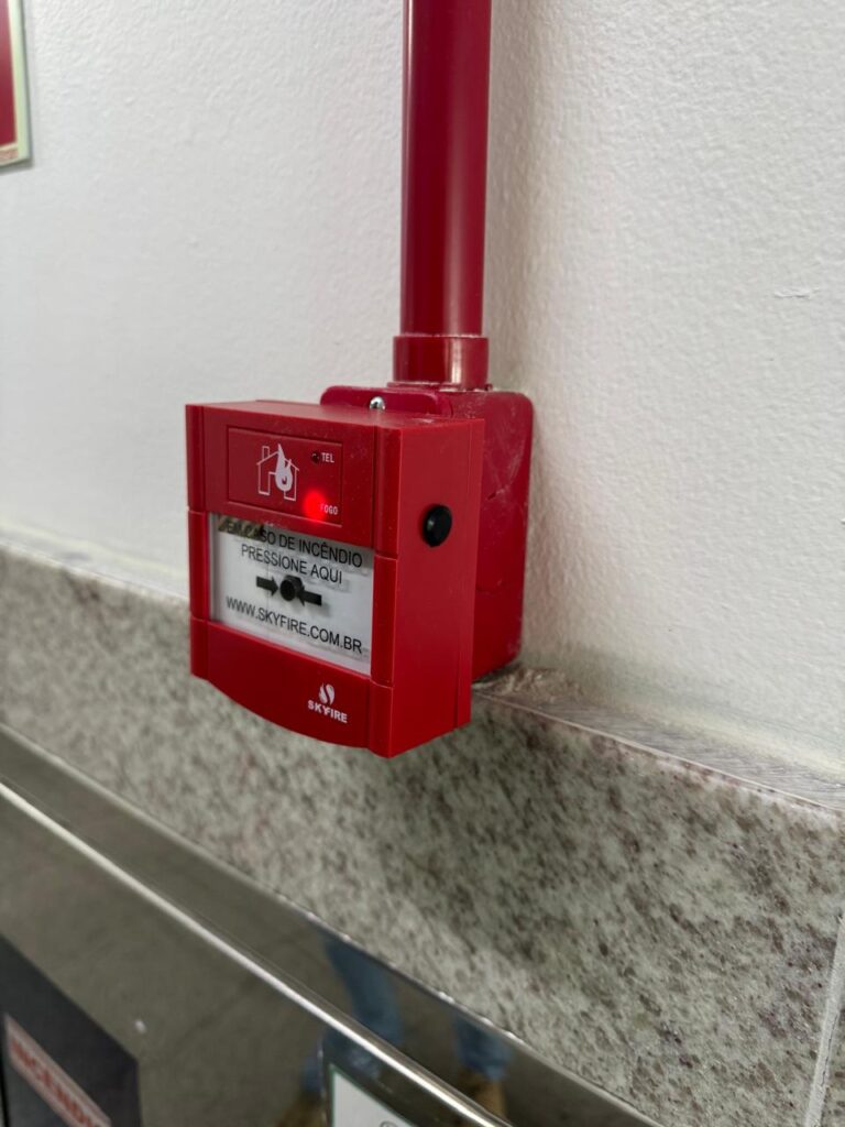 Botão de acionamento de alarme de incêndio utilizado em sistemas de proteção e combate, inspecionado pela LC Engenharia